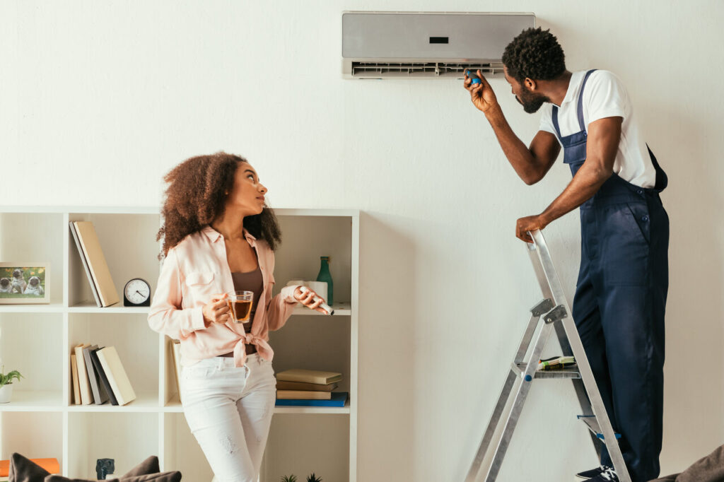 A man diligently works on an air conditioning unit