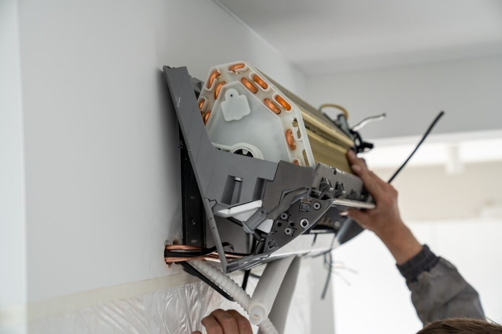 A man is engaged in repairing an air conditioning system